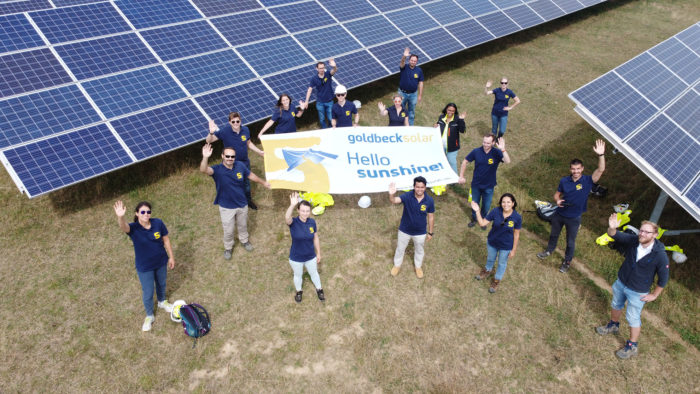 Employees of Goldbeck Solar with a banner with the inscription 